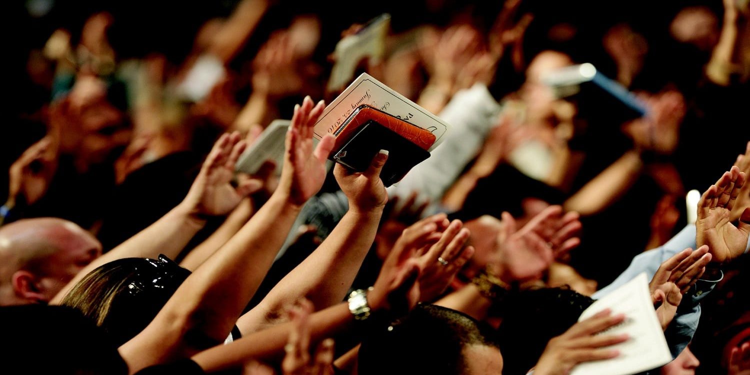 Canva - People Raising Bibles Worshiping God People