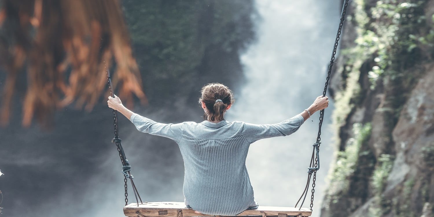 Beautiful woman swings near waterfall in the jungle of Bali island, Indonesia. Beautiful woman swings near waterfall in the jungle of Bali island.